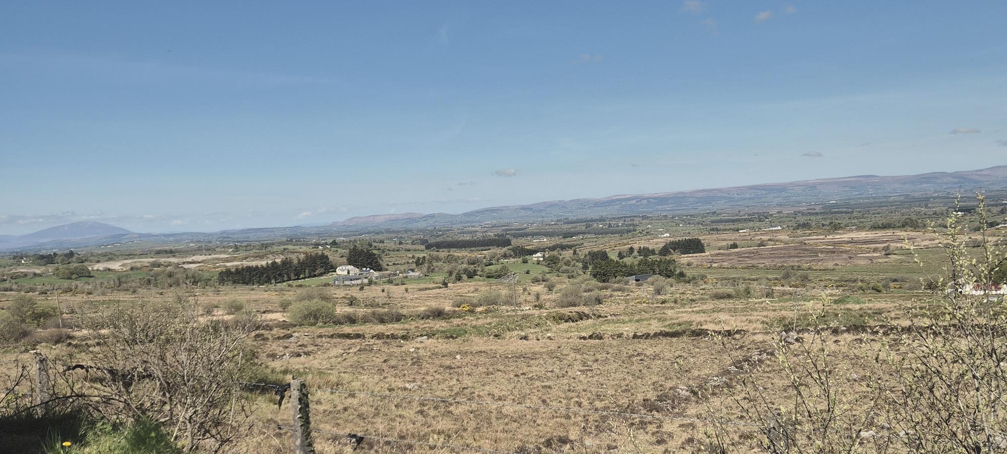 Open bogland and fields in Mayo with mountains on the horizon